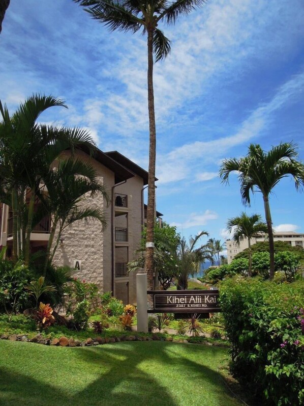 A building with a sign reading "Kihei Alii Kai" and a stone facade.
