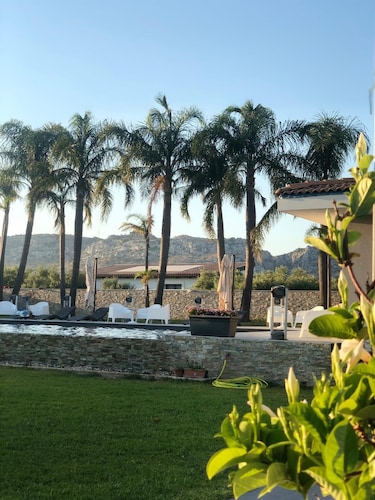 Orange house with large park and swimming pool.