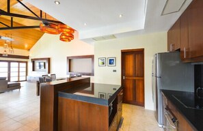 A modern kitchen with wooden cabinets, a central island, and a built-in refrigerator.