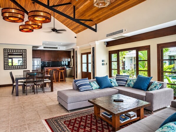 A spacious living area with a sofa, coffee table, and dining set.