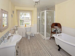 Une salle de bain équipée d’une baignoire, de toilettes, d’une douche et d’un lavabo.