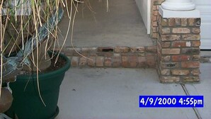 A covered walkway with a brick archway leading to a garage door.