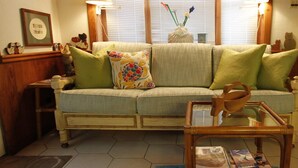 A living room with a sofa, two lamps, a coffee table, and a rug.