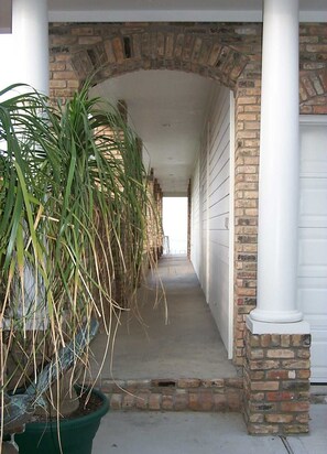 Un pasaje cubierto con un arco de ladrillo que conduce a una puerta de garaje.