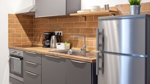 A modern kitchen with a stainless steel refrigerator, a built-in oven, and a coffee maker.