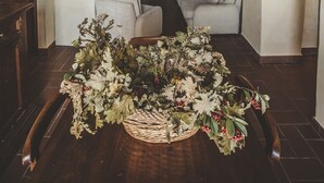 Un accogliente soggiorno con camino, un divano e un'elegante composizione di piante ornamentali.
