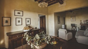 Un soggiorno accogliente con soffitto in legno, un tavolo da pranzo con un cesto di fiori e un divano.