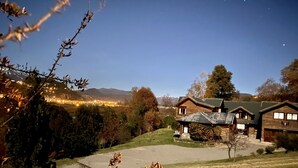 Un cadre rural avec une maison dotée d’un toit en pente et d’un garage apparent.