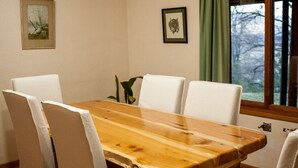 Un coin repas avec une table en bois et quatre chaises blanches.