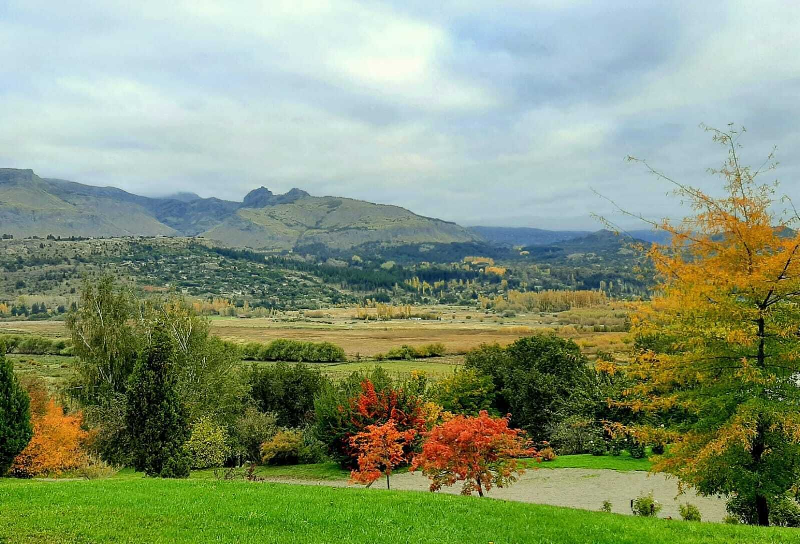 Eine malerische Landschaft mit sanften Hügeln, einem Fluss und Herbstlaub.