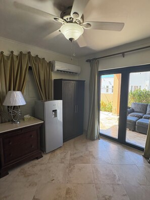 A kitchen with a refrigerator, a ceiling fan, and a window to the outside.