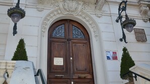 Een gebouw met een bord waarop 'HOTEL DE VILLE' staat, boven een houten dubbele deur.