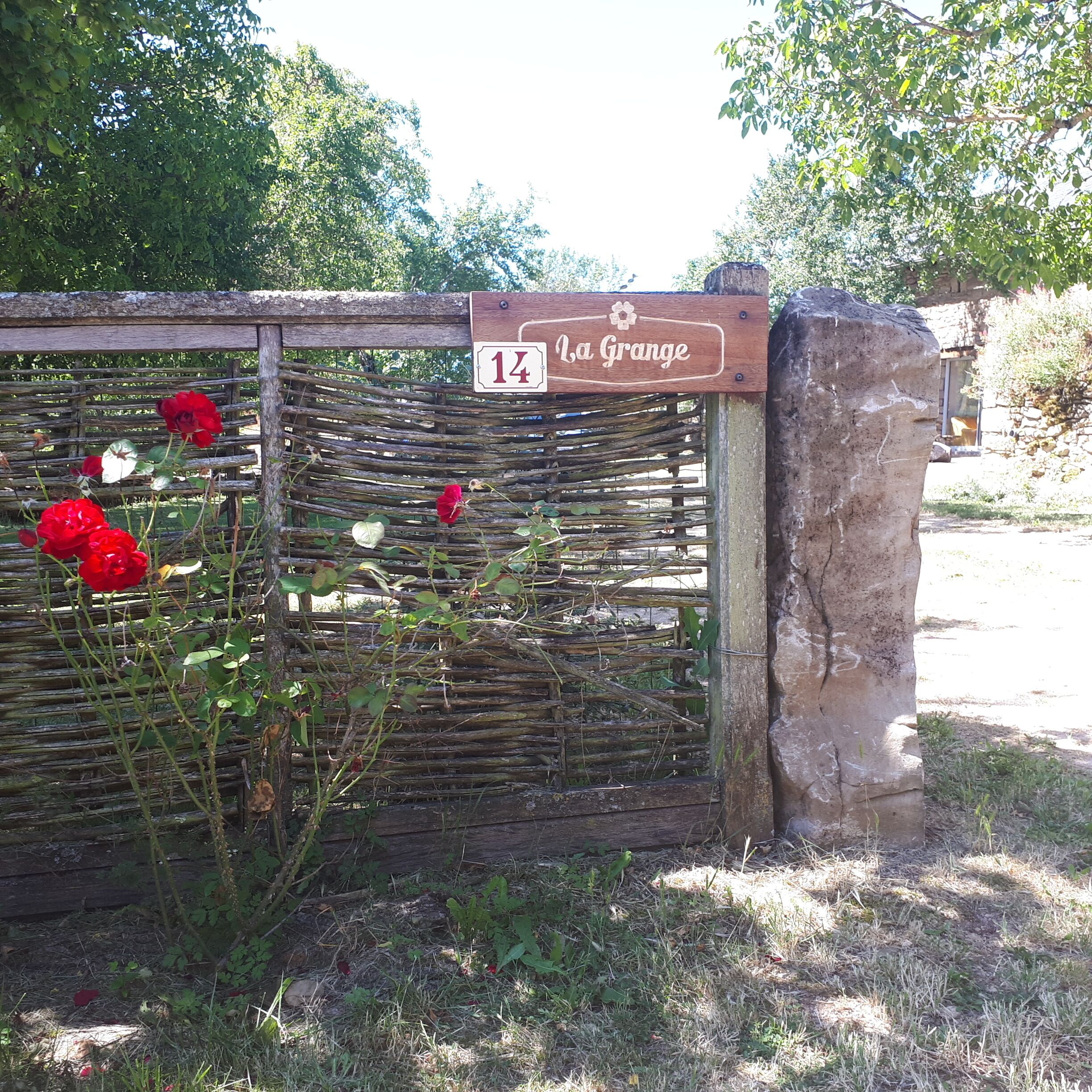 Une porte en bois portant une plaque avec l’inscription « La Grange » et le numéro 14.