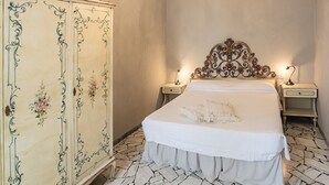 A bedroom with a bed, two bedside tables, a nightstand, a decorative cabinet, and a chandelier. - Spacious Apartment in the Heart of Tuscany (Badia A Cerreto)