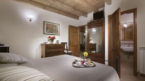 Una camera da letto con un letto, un vassoio con prodotti per la colazione, un quadro e mobili in legno.