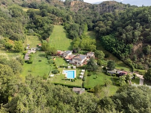 Une vue aérienne d’un vaste domaine comprenant plusieurs bâtiments, une piscine et de grandes pelouses verdoyantes.