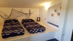 A room with two beds, a wall-mounted net, and decorative butterfly plates. - Seafront house with garden (Cannigione)