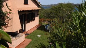 A house with a garden, a clear sky, and a view of the sea. - Seafront house with garden (Cannigione)