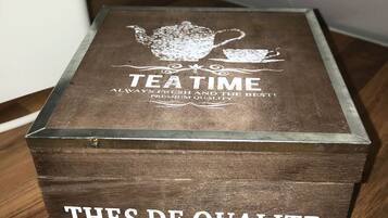 Une boîte en bois sur laquelle on peut lire les inscriptions suivantes : « TEA TIME » et « TOUJOURS FRAIS ET LE MEILLEUR ! QUALITÉ SUPÉRIEURE » sur le couvercle, et « THÉS DE QUALITÉ » sur le côté.