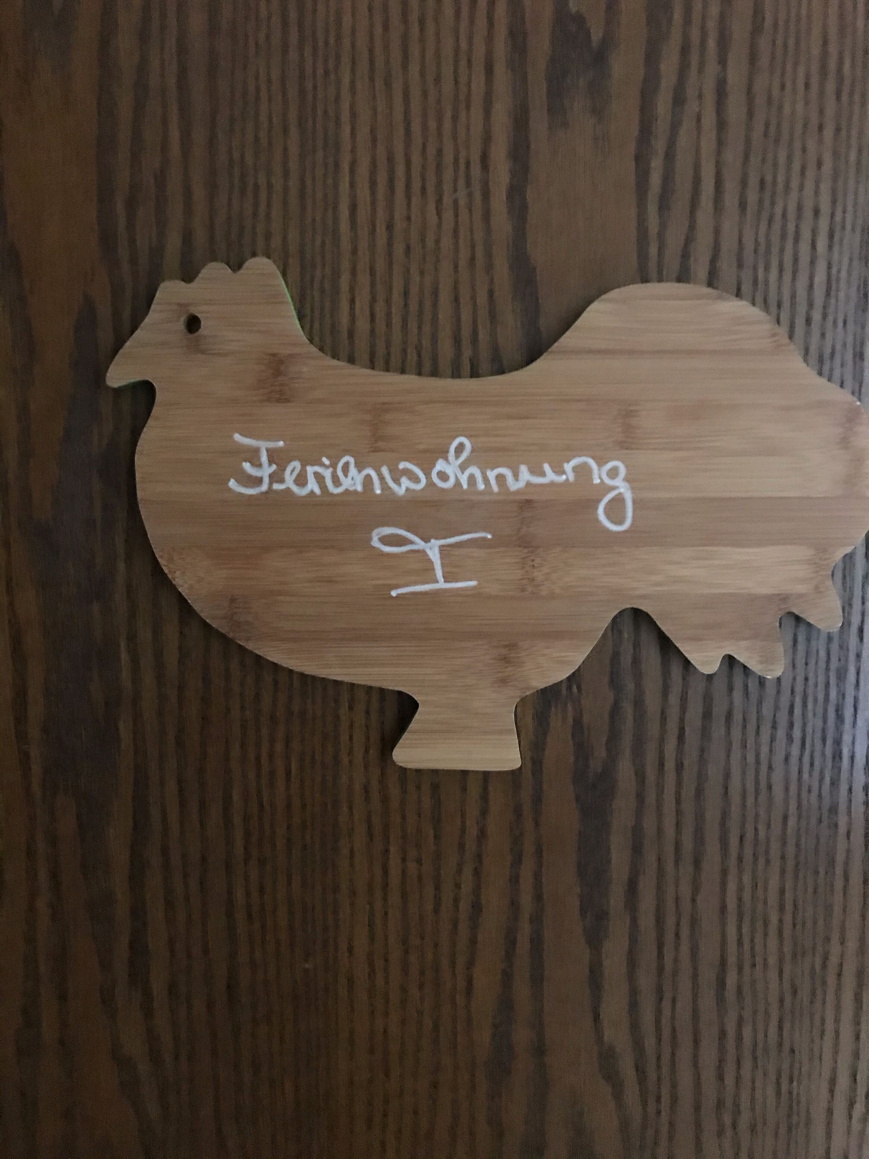 A wooden cutout of a bird with the text "Ferienschwung" on it.