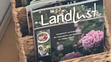 Una cesta de mimbre que contiene un libro titulado 'Landlust' con cubierta floral.