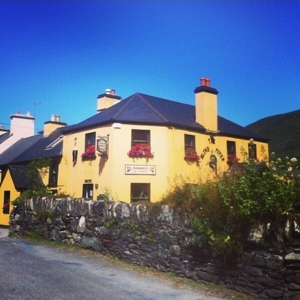 A yellow building with a sign for 'Guinness' and a sign for 'Blind Pig'. - Siobhan's Luxurious Cottage (Castlecove)