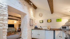 A kitchen with white cabinets, a microwave, a bread box, and a clock on the wall. - 1 bedroom accommodation in Shap, near Penrith (Shap, near Penrith)