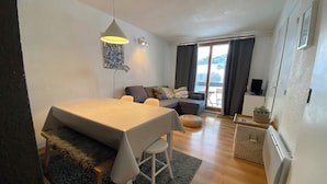 Een moderne woonruimte met een eethoek, een bank en uitzicht op de omgeving.