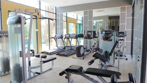 A modern gym with various exercise equipment including treadmills, weight machines, and a rowing machine.