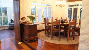 Enjoy meals in this inviting dining area with a large window, a wooden dining table, and comfortable chairs.