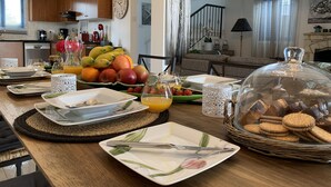 Angolo ristoro con colazione che include frutta, pasticcini e un angolo caffè.