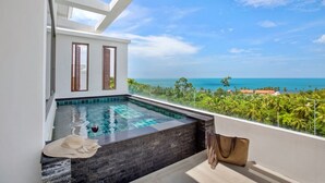 A modern infinity pool with a clear view of the ocean and palm trees.