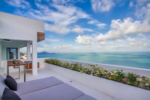 Relax in a serene outdoor space with a clear view of the sea and distant landforms.
