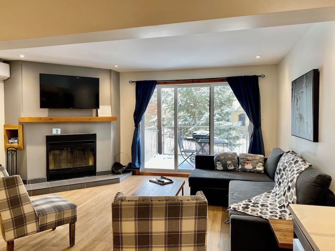 A living room with a fireplace, a sofa, a coffee table, and a television.