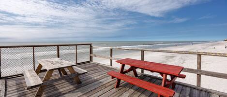 Enjoy a meal on the deck overlooking the sandy beach and ocean.