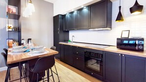 Una cocina moderna con armarios negros, una mesa de comedor de madera y sillas negras.