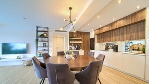 A modern kitchen with wooden cabinets, a built-in oven, and a dining area with a round table and chairs. - Villa Elegant with heated pool (Kvarner - Vrh) (Vrh)