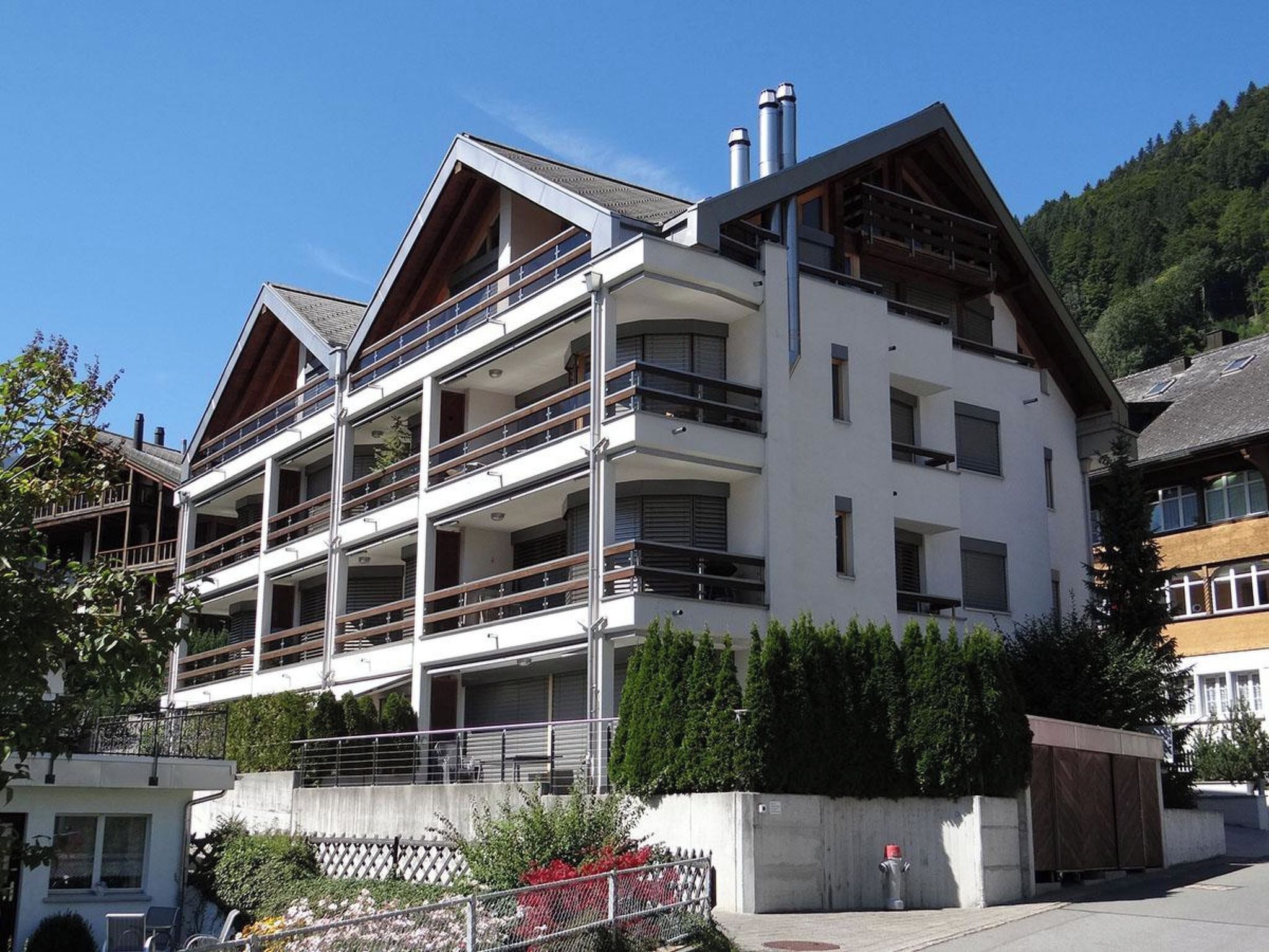 A multi-story building with balconies, a concrete base, and a fire hydrant.