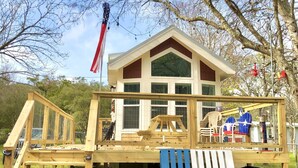 Une terrasse en bois avec une maison, un drapeau et un drapeau du Texas.