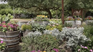 Un jardin avec une enseigne indiquant : « Gristmill River Restaurant & Bar ».