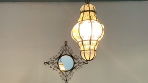 Un luminaire suspendu avec un miroir rond placé en dessous.