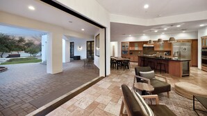 Un'ampia zona giorno con una grande finestra, una cucina dotata di elettrodomestici moderni e un'area pranzo.