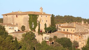 A historic stone building with a tower, surrounded by trees and other buildings. - Sant Mori- La Escala Boutique apartment (Sant Mori)