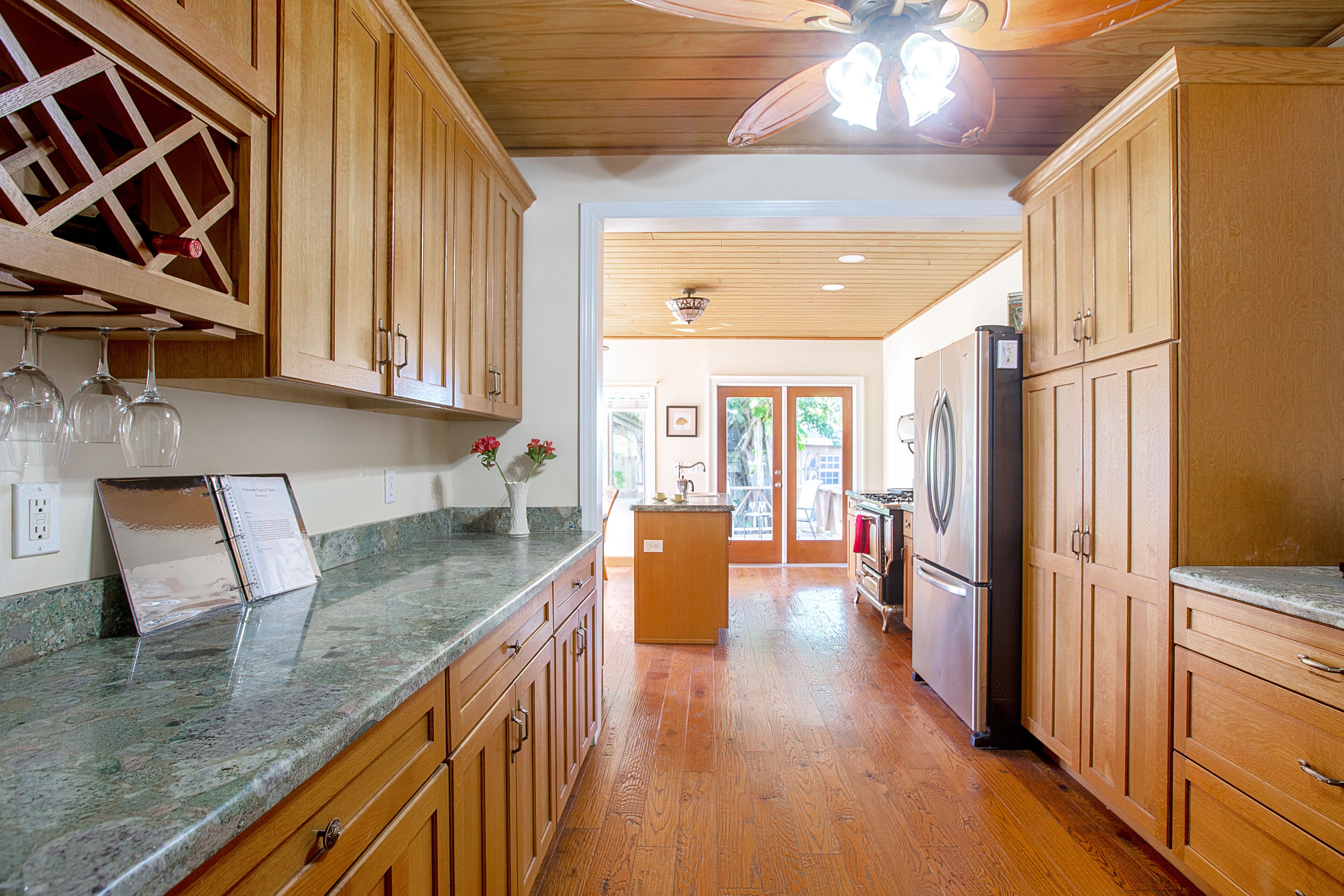 A kitchen with wooden cabinets, granite countertops, and a central island.