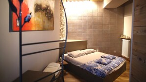 A bedroom with a bed, a nightstand, a painting on the wall, and a wooden ceiling. - Epicurus guest house: Zeus (Somma Lombardo)