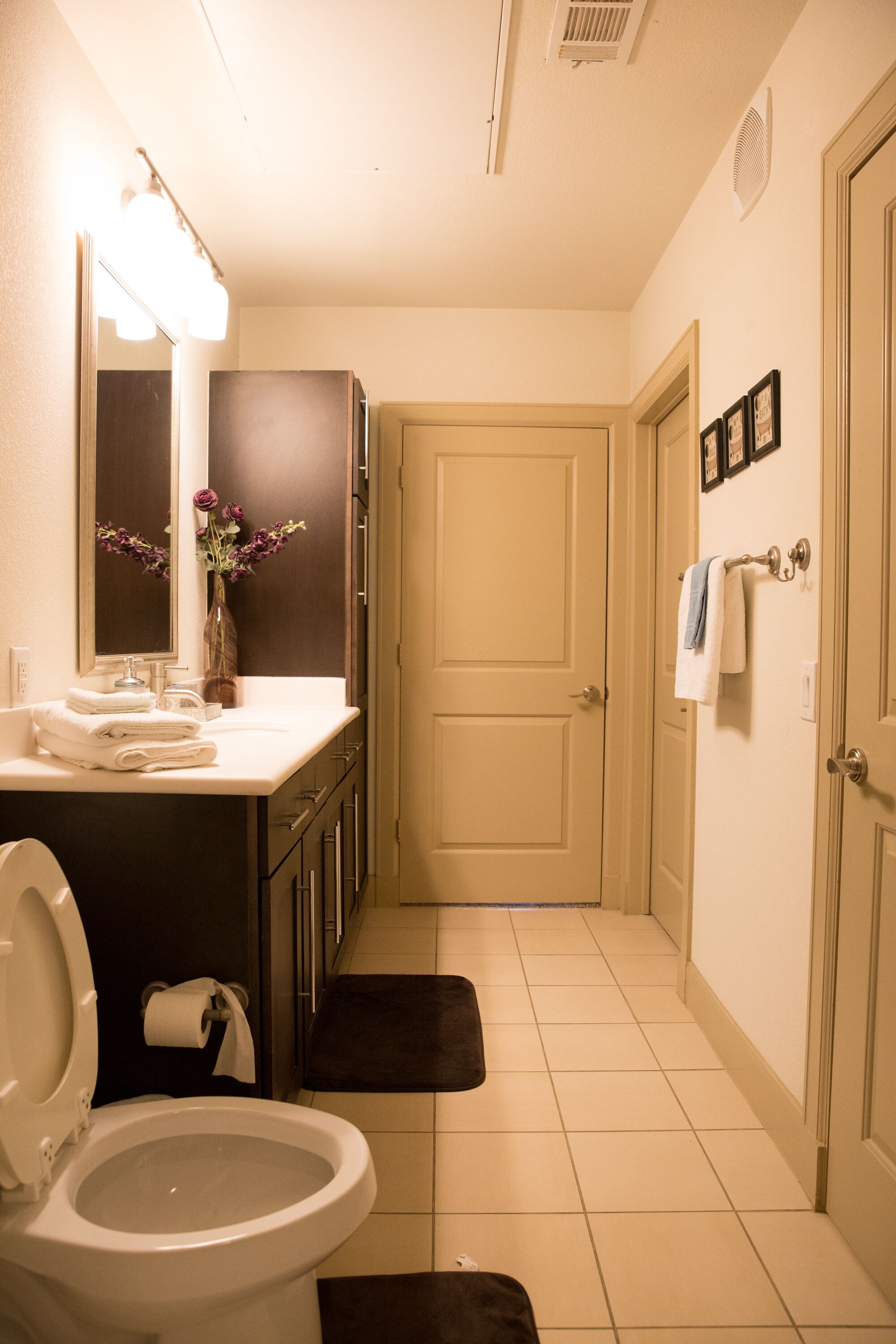 Une salle de bain équipée d’un WC, d’un lavabo, d’un miroir et d’un porte-serviettes.