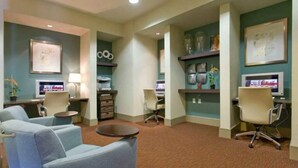 A hotel lobby with seating areas, a reception desk, and decorative items on shelves. - Houston Modern Apt Pool View NRG DISCOUNTED (Houston)