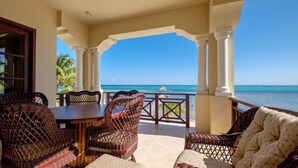 A covered outdoor seating area with wicker furniture, a table, and a view of the ocean. - 606 - 3rd Floor Ocean View Suite (san pedro)