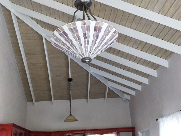 Eine Decke mit einem Ventilator und einer Pendelleuchte.