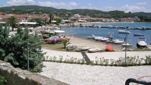 A coastal marina with boats docked, a sandy beach, and a town in the background. - Lovely house with private pool (Unknown)